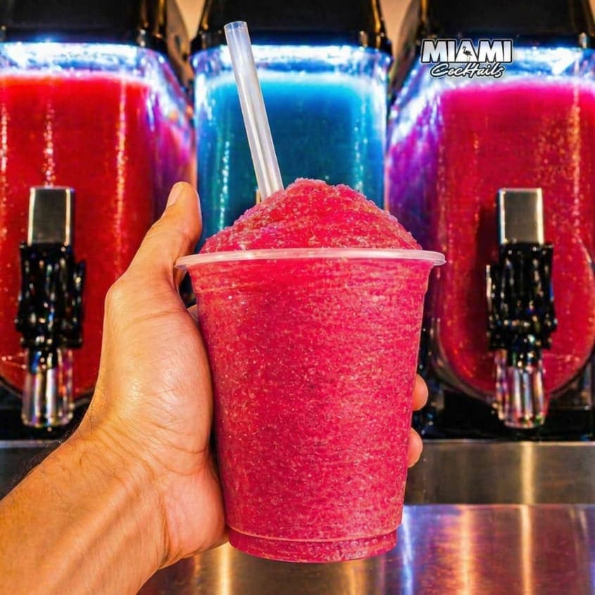Vaso de coctelería granizada servido con hielo y guarnición cítrica